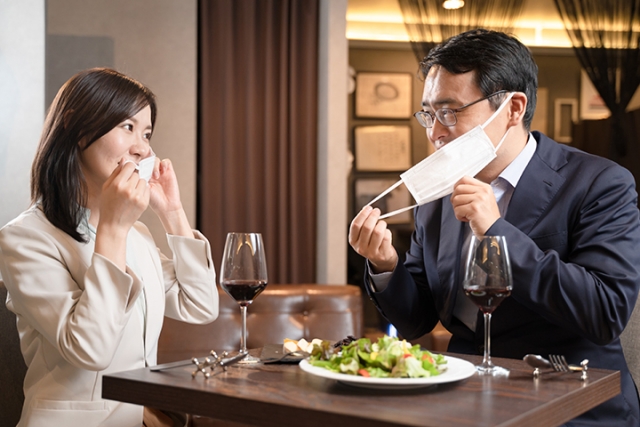 食事中マスクを外す男女