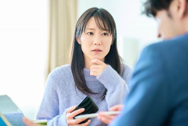 退屈そうに話を聞く女性