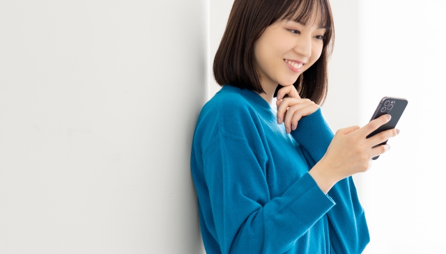 スマホを見て微笑む女性